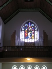 Vue de l'orgue en tribune avec le grand vitrail de façade. Cliché personnel